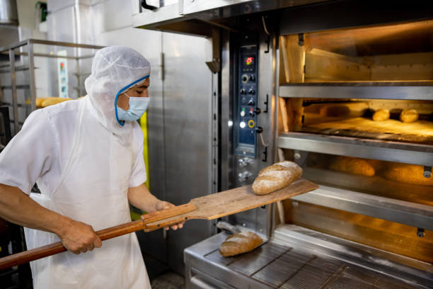 istock Baker putting a loaf of bread in the oven 1412956738