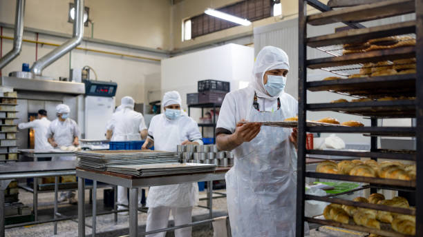 istock Group of workers working at an industrial bakery 1412956748