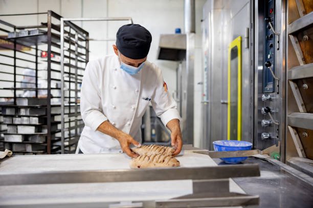 istock Baker baking loafs of bread at an industrial bakery 1412956767