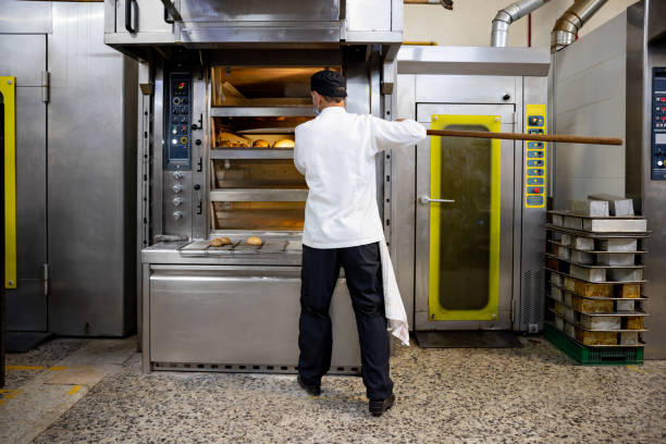 istock Baker taking the bread out of the oven 1412956786