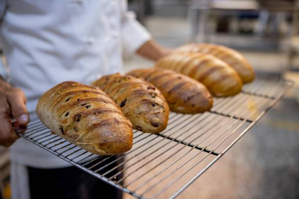 istock Baker carrying a tray of freshly baked bread 1412956790
