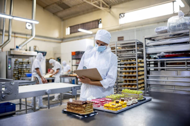 istock Woman working at an industrial bakery and doing quality on some desserts 1412956816