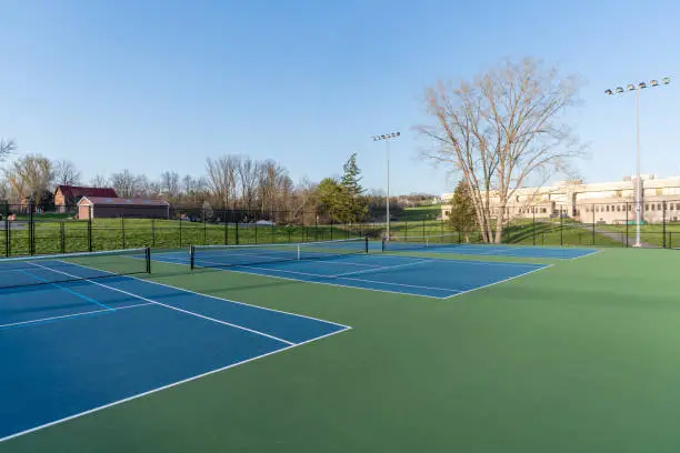 Photo of Close up photo of blue tennis court with pickleball lines.