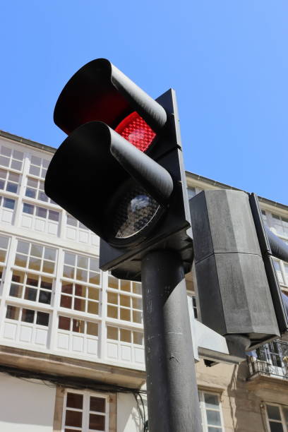 istock Red traffic light with windows in the background. Vertical image. 1412958504