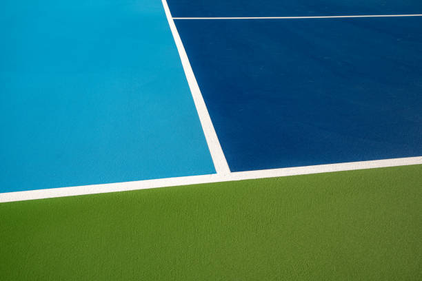 istock Example image of a newly surfaced, empty pickleball court with multi-color surface and white lines. 1412958546