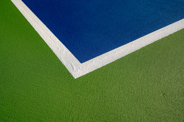 istock Example image of a newly surfaced, empty pickleball court with multi-color surface and white lines. 1412958547