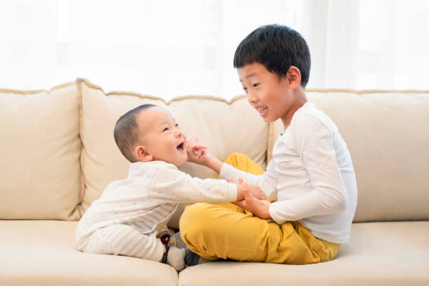 Happy brothers Brothers having fun on the sofa 6 11 months stock pictures, royalty-free photos & images