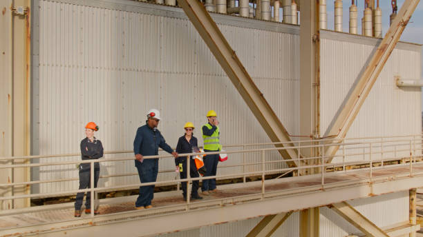 istock Group of Power Plant Workers on External Walkways 1412965371