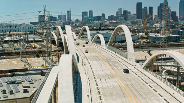 Aerial Shot of Cars Driving Across 6th Street Bridge With Downtown Los Angeles, California in the Distance Aerial shot of the new Sixth Street Viaduct connecting  the Downtown Los Angeles Arts District to Boyle Heights across the Los Angeles River. sixth street bridge stock pictures, royalty-free photos & images
