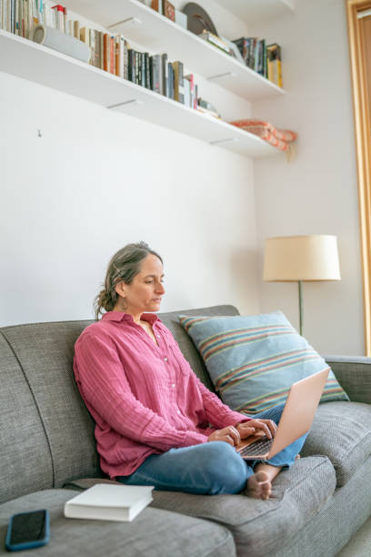 istock Woman relaxing at home and using laptop computer 1412972231