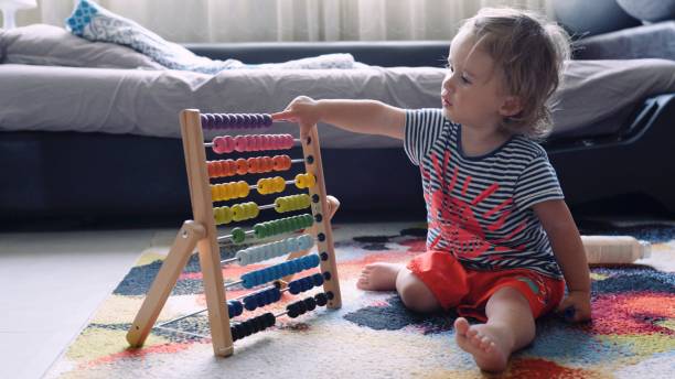 baby plays with wooden colorful abacus toy at home. - criança de 1 a 2 anos imagens e fotografias de stock