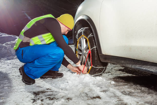 Man put on winter chains for car wheel at snowy road