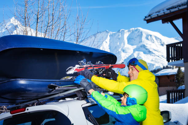istock Farther and son put skies into car box over mountains view 1412972682