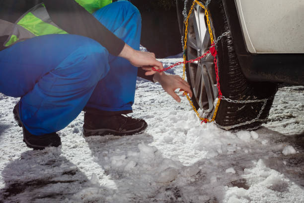 istock Close-up of the man putting winter chains on car wheel 1412972701