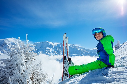 Young boy skier posing on a mountain