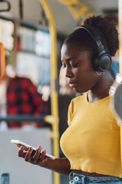 istock African american woman riding a bus and using a smartphone 1412974543