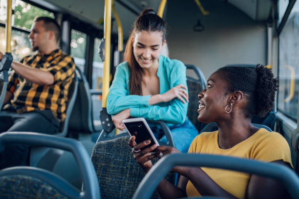 istock Multiracial group of friends talking while riding in a bus and using a smartphone 1412974580