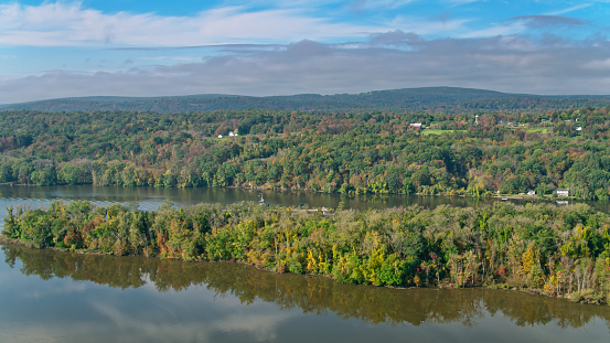 Aerial shot of the Hudson River flowing through woodland just outside Stuyvesant, New York on a clear autumn day.