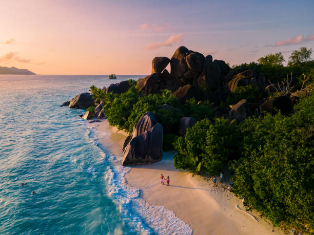 anse source d'argent, la digue seychelles, young couple men and woman on a tropical beach during a luxury vacation in the seychelles. tropical beach anse source d'argent, la digue seychelles - reizen stockfoto's en -beelden