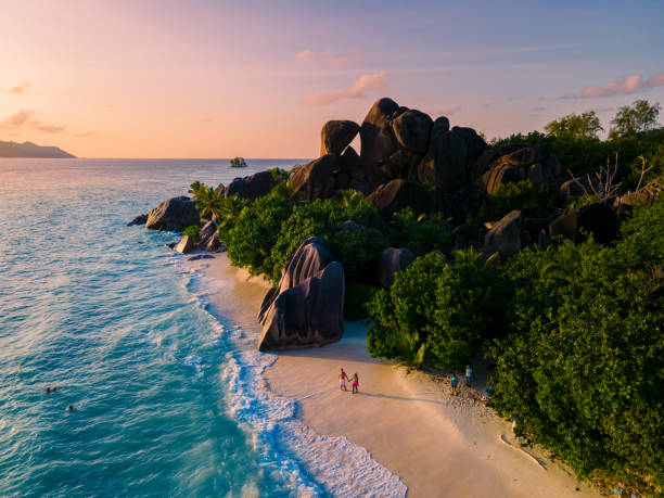 anse source d'argent, la digue seszele, młoda para mężczyzn i kobiet na tropikalnej plaży podczas luksusowych wakacji na seszelach. tropikalna plaża anse source d'argent, la digue seszele - wyspa-land-feature-obrazy zdjęcia i obrazy z banku zdjęć