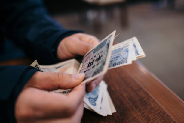 istock Image of a person's hand counting 1,000 yen bills 1412976884