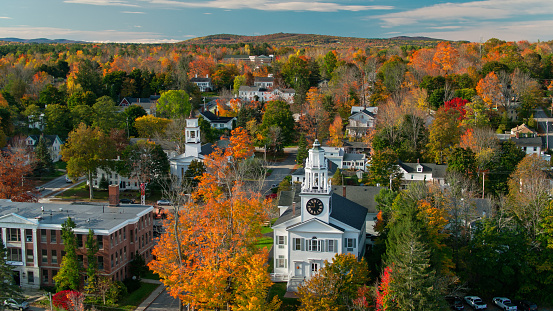 The fall foliage surrounds a quaint New England village in an aerial photogrph
