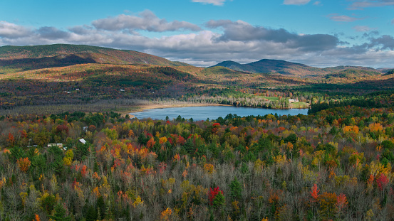 Aerial shot of autumn colors in New England near Sumner, Maine on a partly cloudy day.