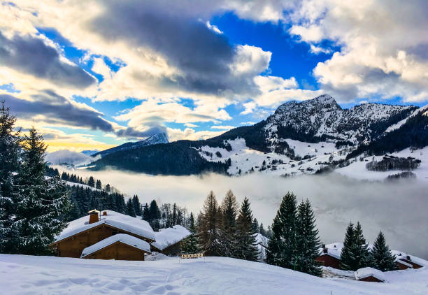 Le Grand Bornand, France - January 11, 2018: The valley in high snow cover, fog, sun, clouds, magical