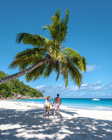 La Digue Seychelles, a young couple of men and women on a tropical beach during a luxury vacation in Seychelles. Tropical beach La Digue
