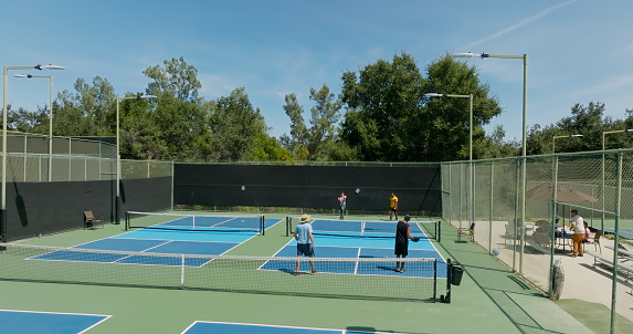 Drone shot of a group of people playing a doubles game of pickleball.