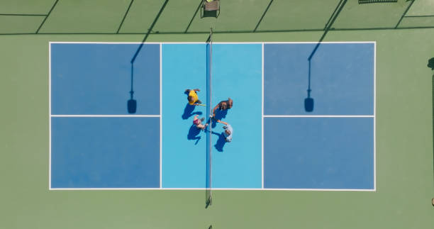 istock Pickleball Players Tapping Paddles Before Doubles Game - Top Down Aerial 1412985104