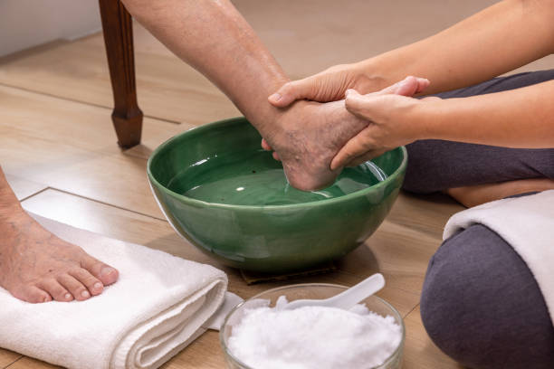 a cuidadora do sexo feminino limpa os pés da idosa por toalha. - asian ethnicity asia massaging spa treatment - fotografias e filmes do acervo