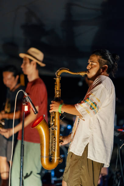 uomo che suona il sassofono in un festival di musica all'aperto - band name immagine foto e immagini stock