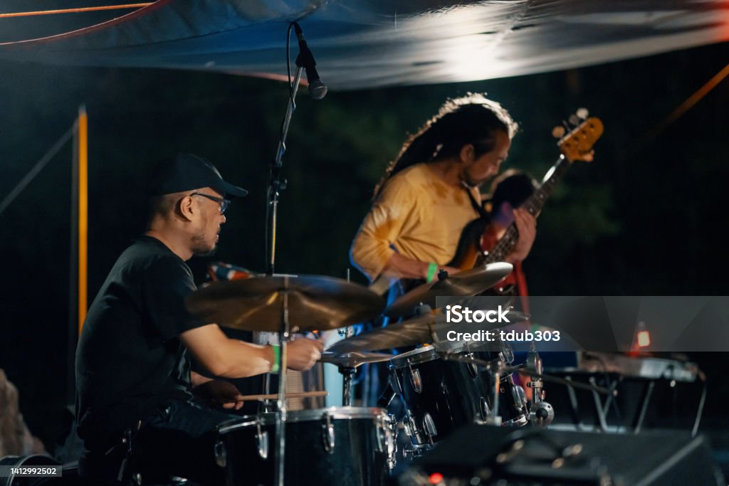 Mid adult man playing the drums at an outdoor music festival Mid adult man playing the drums at an outdoor music festival in Japan at night Jazz Music Stock Photo