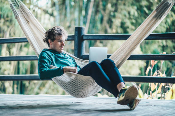 istock Young creative business man works from hammock outdoors 1412992779