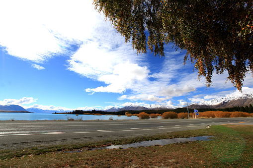 local road  in takapo lake with snow mountain and blue background