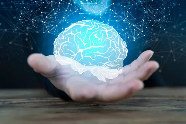 Photo of Abstract palm hands holding brain with network connections, innovative technology