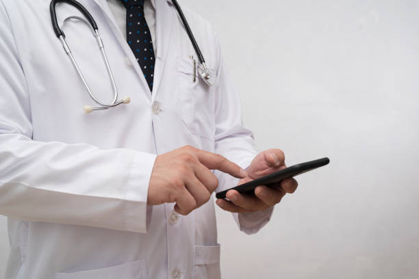 istock Asian smart doctor holding smartphone computer with hand. Surgeon has stethoscopes. 1412995876