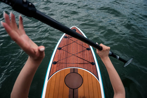 サーフィンをグランダーのために船上のスポーツガール。若い細身の女性がパドルでボードに浮かんでいます。波乗り。水上での夏の楽しみ。健康的なライフスタイル。穏やかな水の上にsup� - paddleboard oar women lake ストックフォトと画像