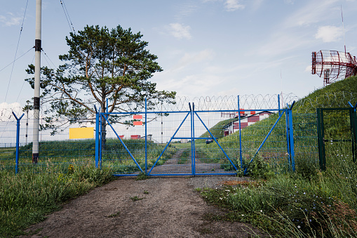 The restricted area is fenced with a metal fence, gates and barbed wire.