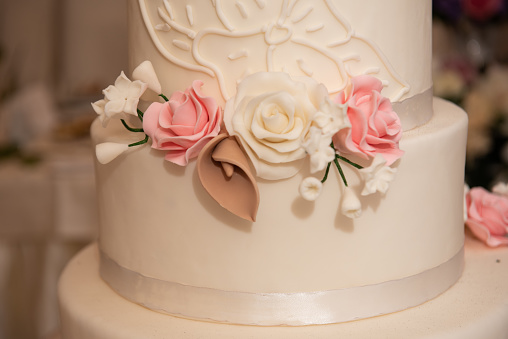 The bride's cake with white and pink roses at the wedding