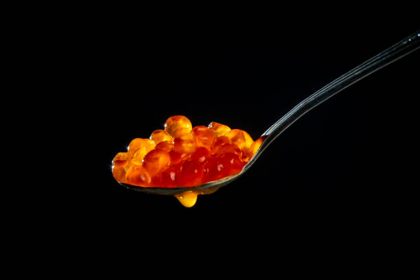 istock Fresh red caviar in a spoon on a black background 1413007065