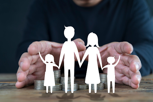 Businessman take a position to protect on paper family in hand, donation, saving, charity, family finance plan concept, fundraising, superannuation, financial crisis concep