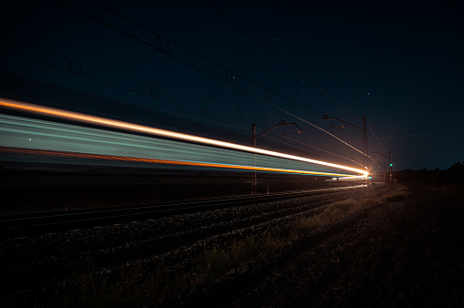 Luminous paths created at night by a passenger train.