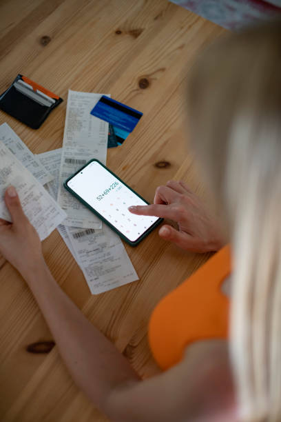 istock Woman Looking at Bills and Checking Expenses With Calculator 1413012693