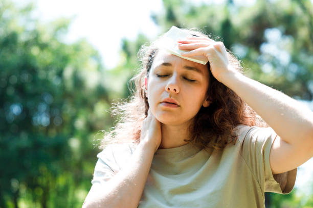 Young woman having hot flash and sweating in a warm summer day stock photo