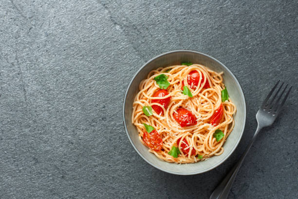 istock Spaghetti with cherry tomatoes top view with copy space on slate background 1413016727