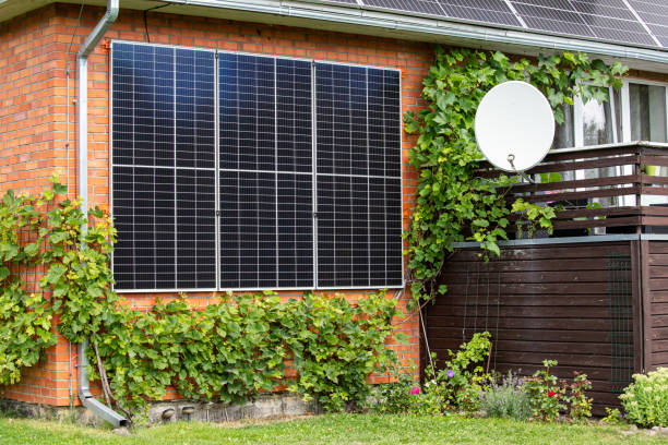 Solar panels attached to a domestic home house for room saving and green energy production. Beautiful garden with grape vines and flowers growing. stock photo