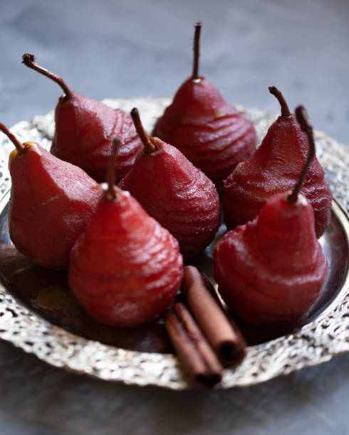 Pears in red wine on a silver plate Pears in red wine with spices on a silver plate silver platter stock pictures, royalty-free photos & images