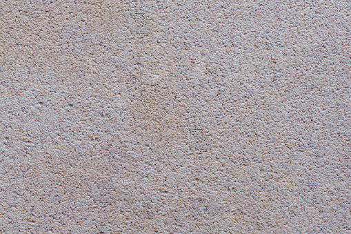 The surface of a brick photographed in extreme detail, showing it's rough textured surface